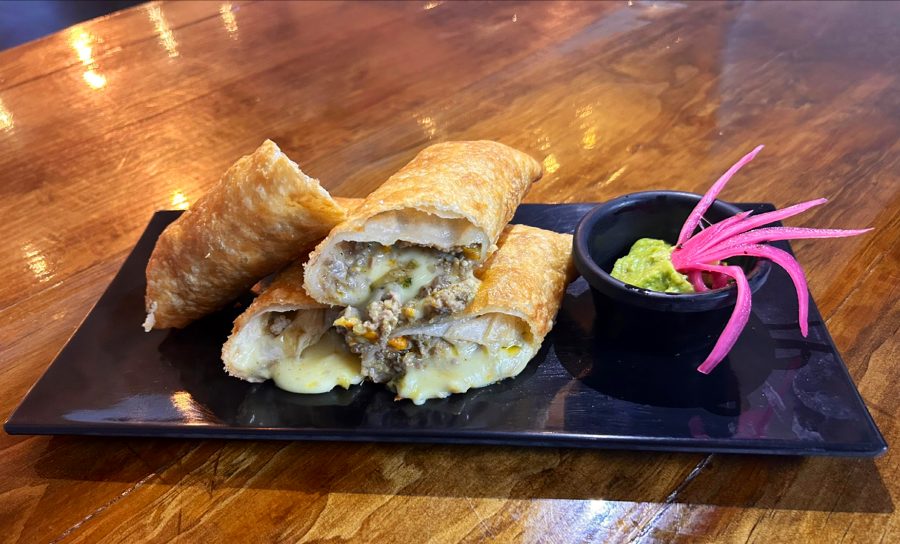 Chimichanga abierta acompañada de guacamole.