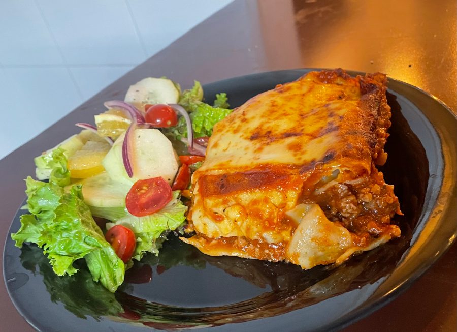 Lasaña servida con ensalada.